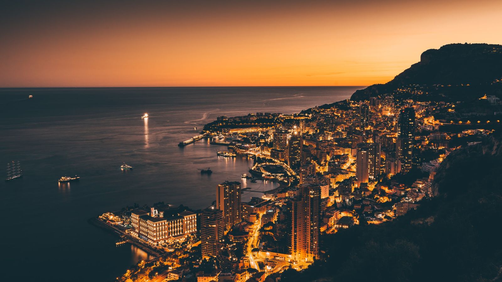 Monaco harbour and coastline lit up at sunset